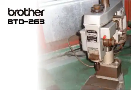 brother ブラザー工業 BT0-263 精密自動タッピングマシン。白と黒の本体が清潔な工場スタジオに設置されている。左上と機械本体にbrotherロゴ、機械にBT0-263の文字。全体はプロフェッショナルでハイテクな雰囲気。中古 即納機ありの説明。