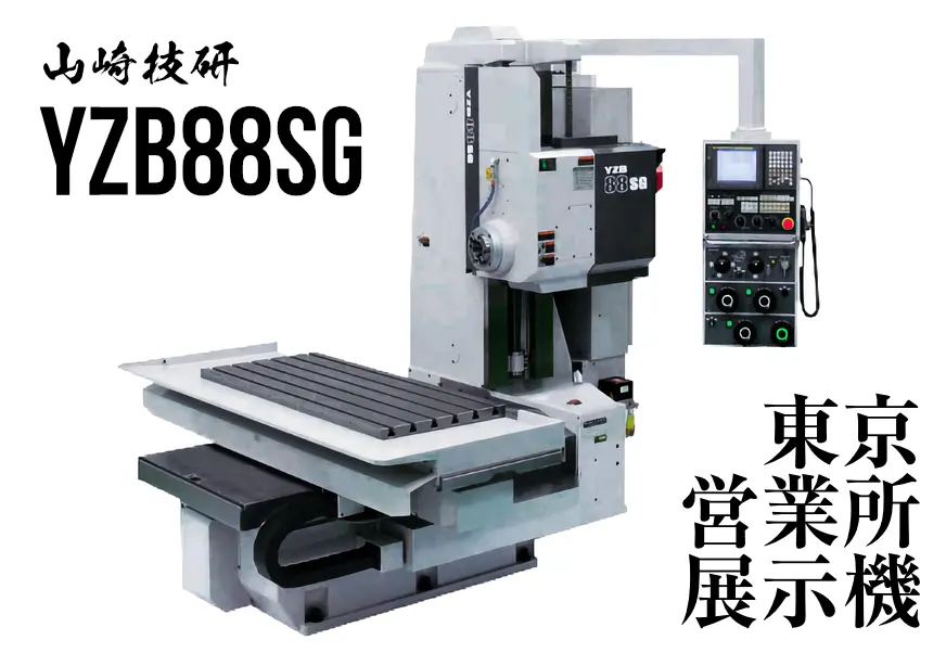 山崎技研 YZB-88SG 超精密横形オープンスタイルNCフライス盤。白と黒の本体が明るい工場スタジオに設置されており、左上にYAMAZAKI GIKENロゴ、機械にYZB-88SGの文字。全体は精密さと先進性を感じさせる静かな雰囲気。